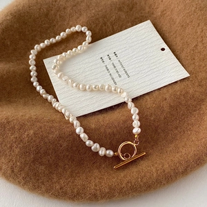 Détail de perles baroques naturelles et fermoir à bascule OT doré sur un collier chic