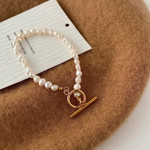 Détail d'un bracelet en perles d'eau douce avec un fermoir à bascule OT doré poli