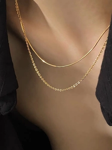 Close-up of minimalist double-layered golden snake chain and link necklace on model