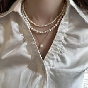 Collier à trois rangs en perles d'eau douce avec chaînes plaquées or et pendentif