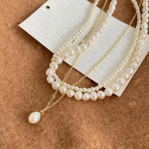 Collier multicouche en perles d'eau douce avec pendentif goutte doré sur laine brune