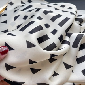 Macro shot of geometric black and white silk scarf showing soft texture and fine fabric