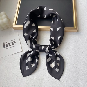 Detail of a black and white geometric silk scarf draped on a decorative display