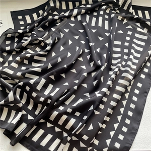 Detail of geometric pattern silk scarf with black and white abstract print texture