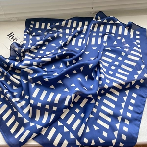 Detail of geometric pattern on blue and white silk scarf showing premium fabric texture
