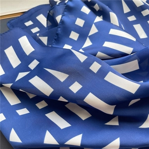 Close-up of lightweight dark blue silk scarf featuring white geometric patterns