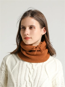 Detail of caramel knit neck warmer with waffle texture and adjustable drawstring bow