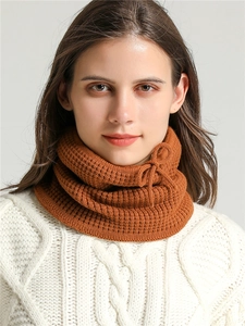 Detail of caramel knit neck warmer showing vertical rib pattern and bow drawstring detail