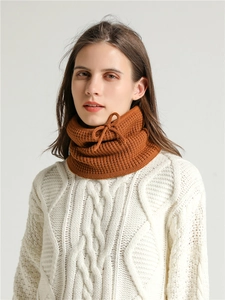Detail of caramel knit neck warmer with drawstring detail and vertical ribbing texture