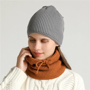Detailed close-up of thick ribbed knit fabric on winter grey hat and caramel neck warmer
