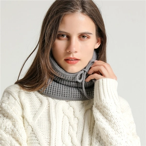 Close-up of gray knitted neck warmer with ribbed texture and adjustable drawstring