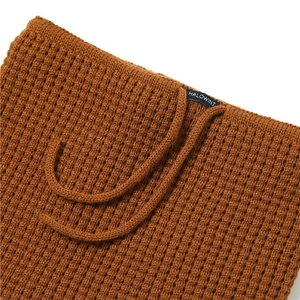 Detail of caramel knitted neck warmer featuring textured knit and adjustable drawstring