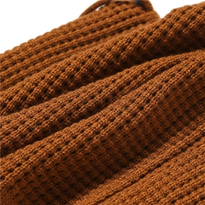 Macro shot of caramel knitted fabric texture showing warm ribbed pattern and soft material