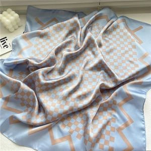 Gros plan détaillé du foulard en soie à carreaux bleu et beige avec texture lisse