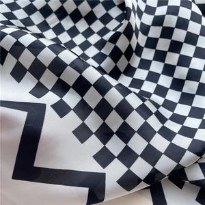 Vue macro du tissu satiné soyeux avec des motifs à carreaux noirs et blancs et éclairs