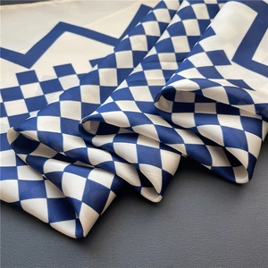 Détail d'un foulard en soie à carreaux bleus et blancs avec des motifs géométriques satinés