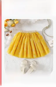 Detail of girls yellow tulle skirt featuring silver rose embroidery and golden sequin waist
