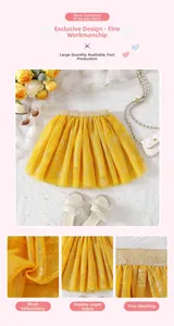 Detail of yellow tulle tutu skirt with flower embroidery and gold glitter waistband