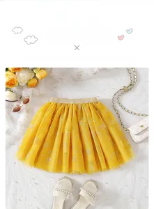 Detail of yellow tulle skirt with gold sequin waistband and starry floral prints