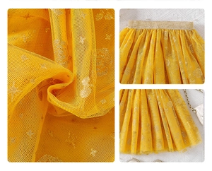 Close-up of yellow layered tulle skirt featuring gold star and rose glitter patterns