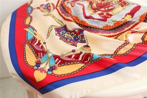 Detail of silk-like satin square scarf showing intricate chain patterns and rolled edges