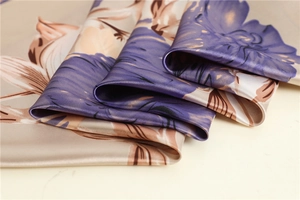 Detailed close-up of floral satin scarf fabric with elegant purple and gold patterns