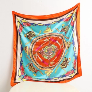 Flat lay of a 90cm square silk scarf with orange borders and blue mandala patterns