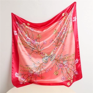 Detailed view of the pink butterfly and floral pattern on a silky satin square scarf