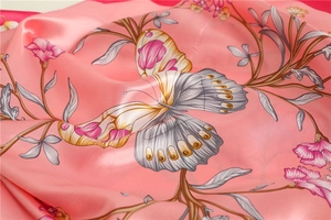 Macro view of silky satin butterfly and floral print scarf with refined texture
