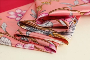 Detailed macro view of pink floral pattern on premium satin silk scarf with pearly luster