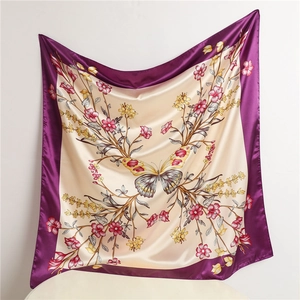 Detailed view of silk scarf with colorful butterfly and floral patterns on beige