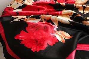 Macro shot of elegant floral print on silky satin scarf with vibrant red and gold patterns