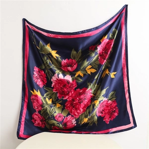 Detailed view of square silk scarf featuring navy blue and pink floral patterns
