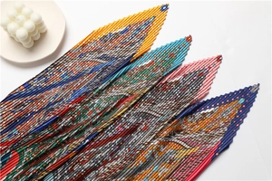 Détail macro de foulards plissés multicolores aux motifs équestres et de chaînes