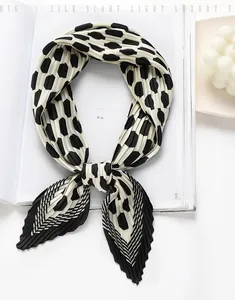 Detailed view of black and white polka dot pleated scarf with unique crinkle texture