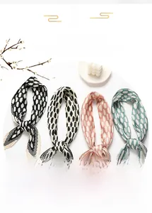 Detail of pleated silk-like scarves featuring elegant polka dots and V-shaped ends