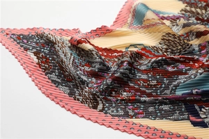 Détail d'un foulard en soie plissé avec motifs géométriques et texture en accordéon