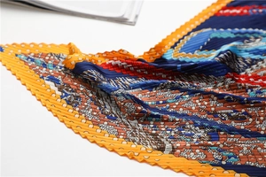 Détail rapproché d'un foulard en soie plissé aux motifs géométriques et pois colorés