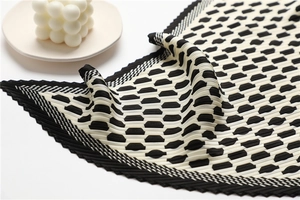 Detail of pleated silk scarf with black and white polka dots and sawtooth edges