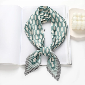 Green pleated silk scarf with white polka dots on a minimalist white background