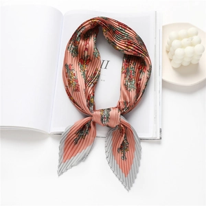 Detail of coral orange floral pleated scarf with elegant edge contrast on magazine