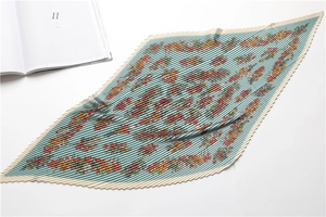 Macro detail of diamond pleated silk scarf with floral patterns and organza texture