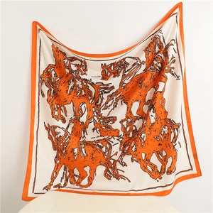 Detail of silk square scarf featuring orange horse prints and classic equestrian patterns