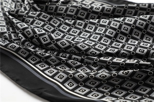 Gros plan détaillé montrant la texture lisse et les motifs géométriques du foulard