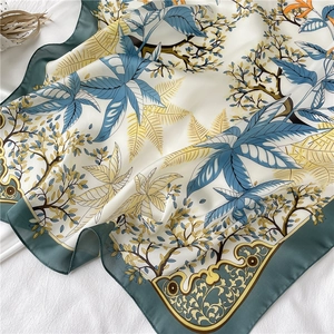 Vue détaillée du motif de feuilles sur un foulard carré en soie de 70 cm à bordure verte