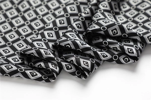 Gros plan du foulard en soie à motif géométrique montrant sa texture satinée
