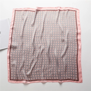 Détail d'un foulard en soie rose à motifs géométriques, carreaux vintage et bords roulés
