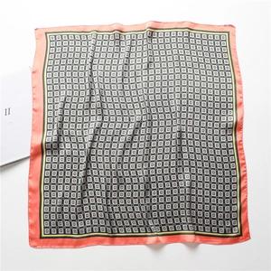Détail d'un foulard carré en soie à motif géométrique avec des bordures rose tendre