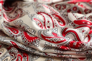 Makroaufnahme eines luxuriösen Seidenschals mit Paisleymuster und Satin-Glanz-Textur