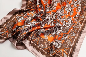 Makroaufnahme der Seidenschal-Textur mit orange-braunem Paisley-Muster aus Satin